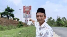 Muslim Taher Tokoh Masyarakat Pesawaran menunjukkan baliho Nanda Indira Program Pemerintah Kabupaten Pesawaran. Foto : Ist