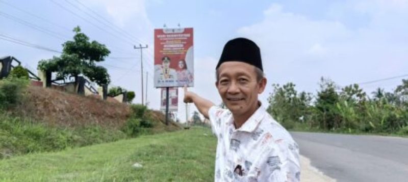 Muslim Taher Tokoh Masyarakat Pesawaran menunjukkan baliho Nanda Indira Program Pemerintah Kabupaten Pesawaran. Foto : Ist