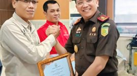 Kepala Kejaksaan Tinggi Lampung, Kuntadi menyerahkan piagam penghargaan kepada Ketua PWI Lampung Wirahadikusumah. Ilustrasi: berandalappung/Wildanhanafi