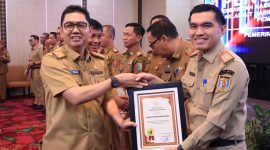 Penjabat Sekretaris Daerah Provinsi Lampung, Fredy, menyerahkan piagam penghargaan kepada pemerintah kabupaten/kota. Foto: Biro Adpim
