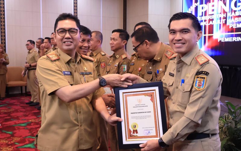 Penjabat Sekretaris Daerah Provinsi Lampung, Fredy, menyerahkan piagam penghargaan kepada pemerintah kabupaten/kota. Foto: Biro Adpim