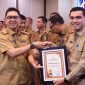 Penjabat Sekretaris Daerah Provinsi Lampung, Fredy, menyerahkan piagam penghargaan kepada pemerintah kabupaten/kota. Foto: Biro Adpim