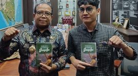 Penulis Buku berjudul dari guru menjadi gubernur Luki Pratama menyerahkan buku kepada PJ gubernur Lampung Samsudin. 